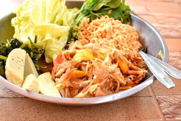 Spicy papaya salad or Thai called SomTum, side dish with mixed vegetables,  egg and instant noodles. Yummy easy cooked at home.