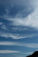  A Vibrant atmospheric cloudy sky cloudscape with white coloured wispy cirrus cloud formation in a mid blue sky.