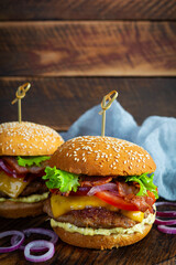 Delicious beef hamburger with bacon slice, cheese, lettuce and tomato. Tasty fastfood burger