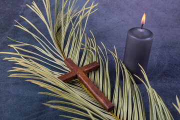 Catholic Cross with palm leaf and burning candle. Ash Wednesday, Lent season, Holy Week, Good Friday and Palm Sunday concept. Copy space. - obrazy, fototapety, plakaty