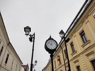 Fototapeta na wymiar clock and buildings in Baia Mare city, Romania