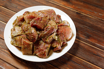 The amazing cook placed the white plate of barbecue on the table in front of the visitor.