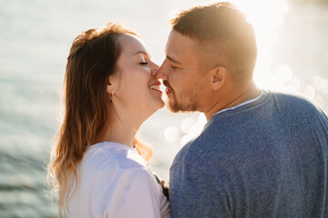 profiles couple in love kissing on the sea beach. solar glare