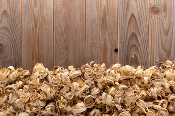 Wood shavings at table background. Wooden shaving on old plank board - 481035447