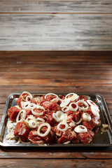 The chef is preparing a dish with the barbecue and onion.
