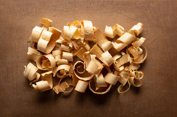 Wood shavings at table background. Wooden shaving on old plank board