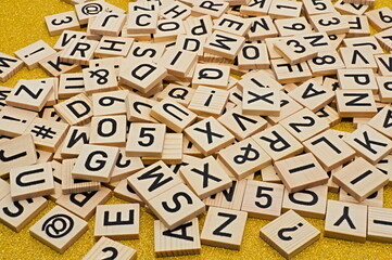 The letters of the alphabet loosely spread out on the table. Inertly shaped on a bright surface.