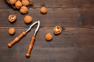 walnuts in the shell and a nutcracker on a wooden background,copy space