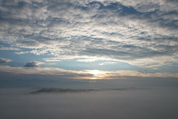 Between the clouds- hills getting from inversion layer on the ground and other layer of high...