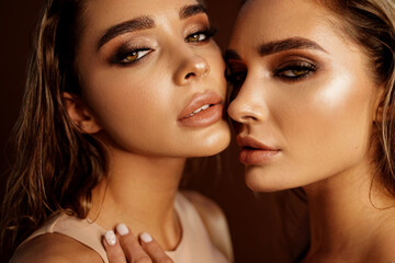 Beauty portrait of two beautiful young women with glowing glamour makeup and long wet hair. Aesthetic medicine concept. - obrazy, fototapety, plakaty