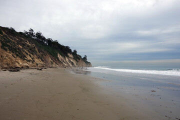 Pacific ocean coastline looking south in Santa Barbara with bluffs, beach, ware and sky on a winter day