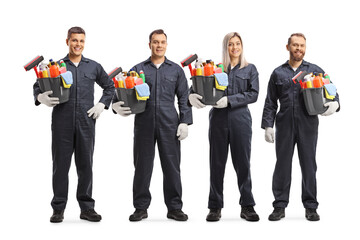 Group of young professional cleaners in uniforms holding buckets with cleaning supplies
