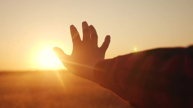 hand reaches for the sun. religion life freedom concept. girl pulls her hand to the sun at sunset close-up nature energy. religion work on lifestyle oneself concept