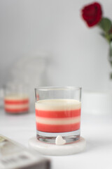 Vanilla and strawberry panna cotta in a glass, cooked cream dessert in a glass cup, white and pink...
