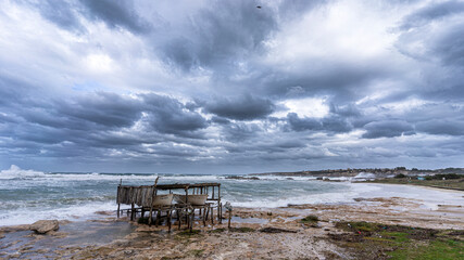 Fototapeta na wymiar Stormy coast of For where there is a typical wooden boathouse