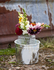 Colorful flowers in a paint bucket.