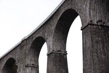 Close-up stone arched railway bridge in high key lighting