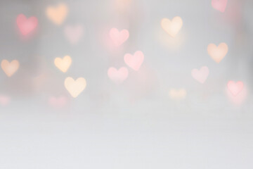 Valentine background mockup with pink and yellow heart shaped light bokeh on a grey seamless...