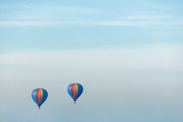 Large balloons float against the background of the blue sky. The concept of aeronautics.