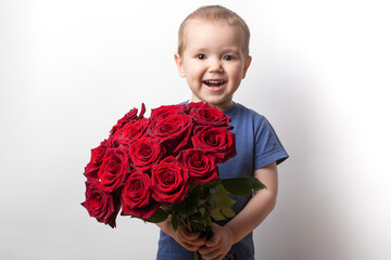 happy little boy with a bouquet of red roses .portrait on a white background.