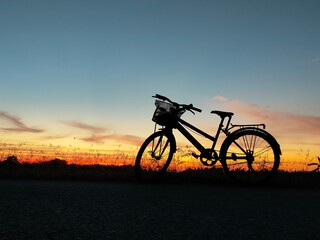 Fototapeta na wymiar bicycle silhouette under the sunset sky background