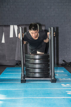 man pushing weight sled at gym in Bangkok