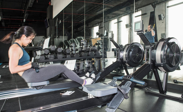 woman training with rowing machine at gym in Bangkok