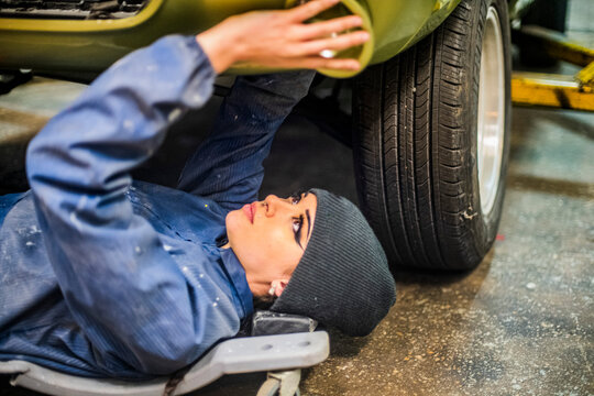 Female Auto worker prepping under car