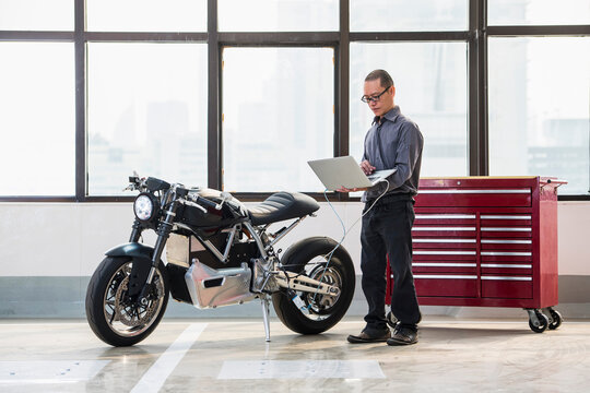 technician checking electric motorcycle at workshop