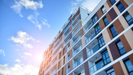 Fototapeta premium Facade apartment building with many windows balcony against blue sky