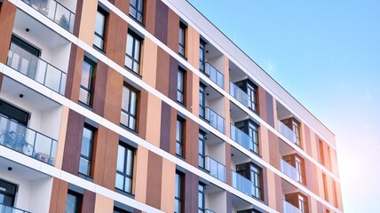 Facade apartment building with many windows balcony against blue sky