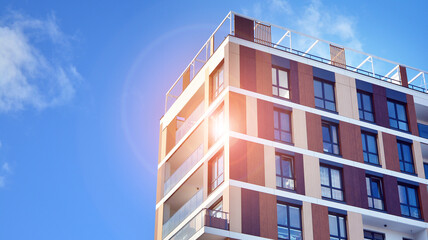 Facade apartment building with many windows balcony against blue sky