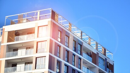 Facade apartment building with many windows balcony against blue sky - obrazy, fototapety, plakaty