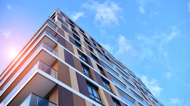 Facade apartment building with many windows balcony against blue sky