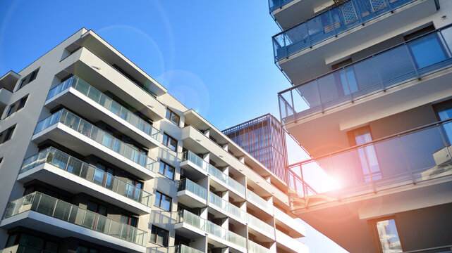 Facade apartment building with many windows balcony against blue sky