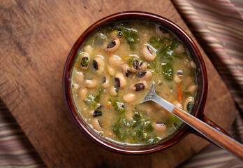 Black eyed peas and collard greens in a brown bowl