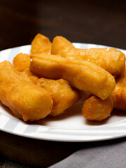 Chinese style porridge or porridge and fried dough stick or fried dough stick or donut or fried bread placed on a brown wooden table. Thai street food called 