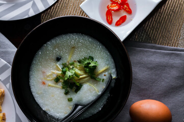 Chinese style porridge or porridge and fried dough stick or fried dough stick or donut or fried bread placed on a brown wooden table. Thai street food called 
