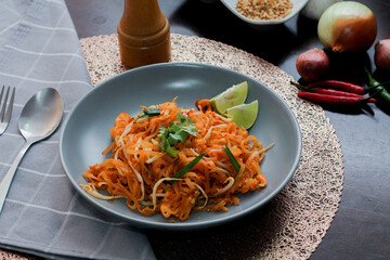 Thai Food Pad Thai (Thai national dish) Pad Thai on a gray plate with lime and garnishes.