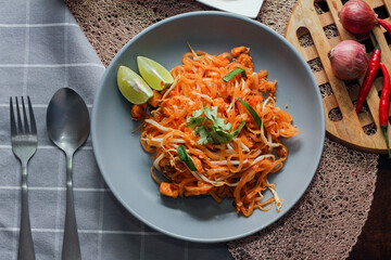 Thai Food Pad Thai (Thai national dish) Pad Thai on a gray plate with lime and garnishes.