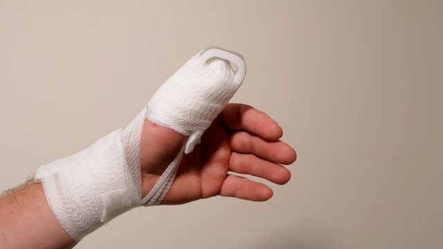 Broken finger.Bandage and splint on the finger. White bandages. 4k footage