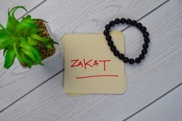 Zakat write on sticky notes isolated on Wooden Table.
