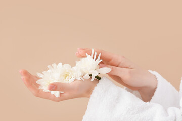 Female hands with fresh flowers on color background