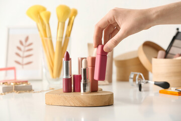 Woman with different lipsticks on table