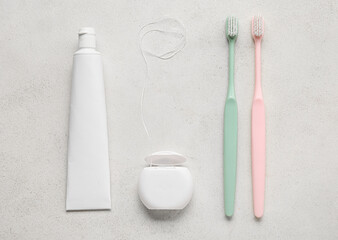 Dental floss with tooth brushes and paste on white background
