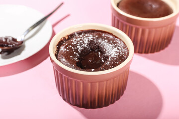 Ramekin with tasty lava cake fondant on pink background, closeup