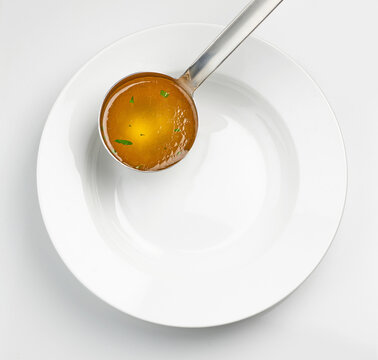 empty white soup plate and broth ladle