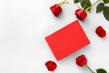 Composition with blank card and red rose flowers on white background. Valentine's Day celebration