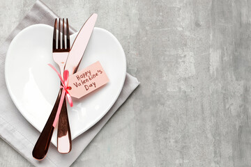 Beautiful table setting and tag with text HAPPY VALENTINE'S DAY on grunge background