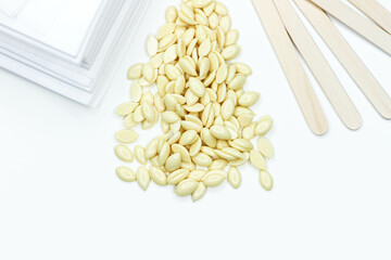 Hair removal wax. Wax strips for depilation. Spatula and wax granules.